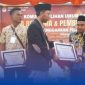 Ketua KPU Sumenep, Nurussyamsi, menyerahkan penghargaan kepada PPK dan PPS terbaik dalam acara pembubaran badan ad hoc Pilkada Serentak 2024 di Gedung Korpri Sumenep, Senin (27/1/2025).